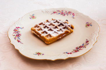 Delicious waffle with powdered sugar on a dessert plate