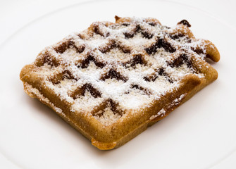 Delicious waffle with powdered sugar on a dessert plate