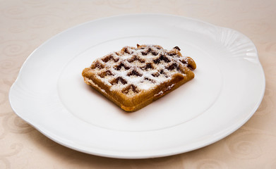 Delicious waffle with powdered sugar on a dessert plate