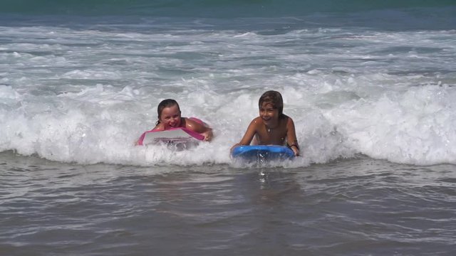 Young children bodyboarding in the Atlantic ocean