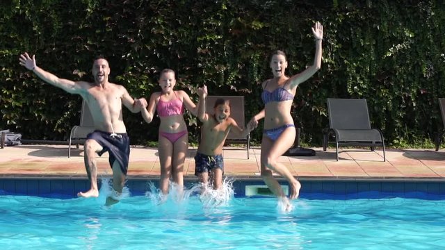 Cheerful family jumping in swimming-pool
