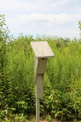 A close view of the old wood birdhouse in the field.