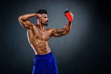 Fototapeta na wymiar Handsome Muscular Men Holding Protein Drink Bottle