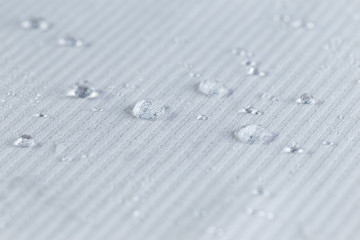Water drops on white striped waterproof fabric.