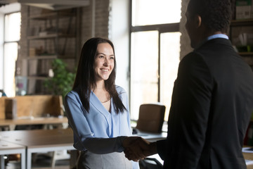 Smiling businesswoman handshaking with executive, getting job or reward