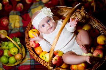 little girl and a full basket of apples