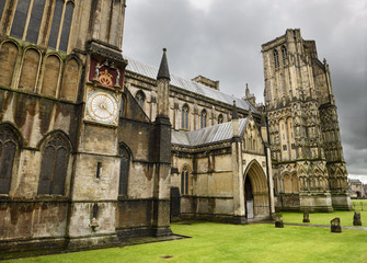 The north transept with its Medieval clock face the north porch and north-west tower of Wells Cathedral under rain clouds Wells England
