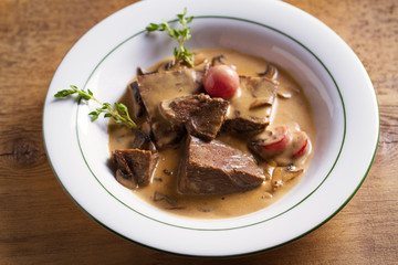 Braised veal cheeks in cream sauce with mushrooms