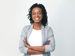 Young Black Businesswoman Smiling At Camera Crossing Hands, Studio Shot
