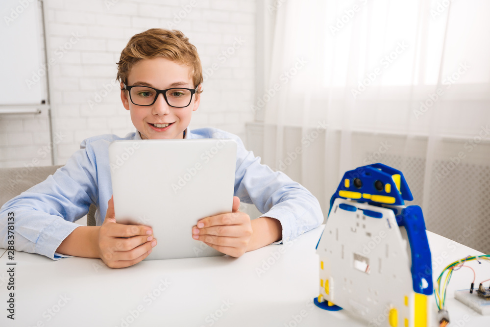 Poster Boy programming robot with digital tablet in class