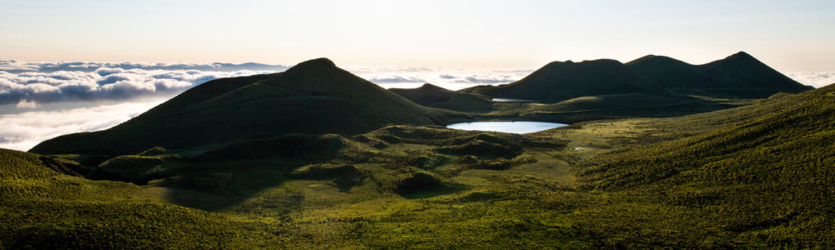 Amazing panorama landscape above the cloudline at Pico Island showing Lago de Peixinho (Lagoa do Peixinho), green meadows and clouds above the Ocean.