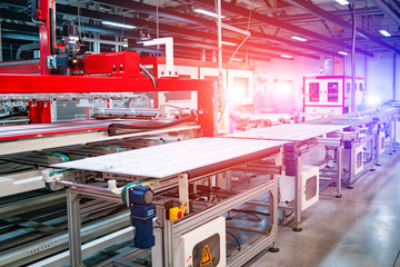 workers and machinery in a solar panel manufacturing industry factory. The source of ecological renewable energy.