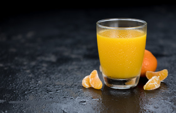 Fresh made Tangerine Juice (on a slate slab; selective focus)