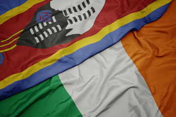 waving colorful flag of ireland and national flag of swaziland.