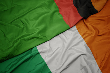 Obraz premium waving colorful flag of ireland and national flag of zambia.