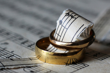 Two wedding rings and old musical notes