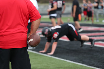 A football coach warms up his team prior to a game