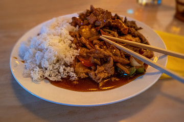 Asian fast food style, fried chicken with vegetables, rice and wooden chopsticks