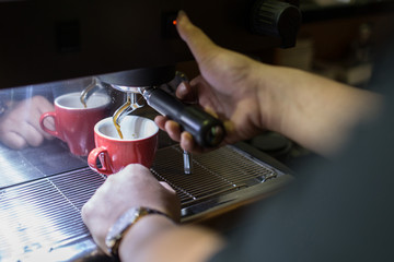 Barista making fresh coffee going out from a coffee espresso machine for delicious coffee.