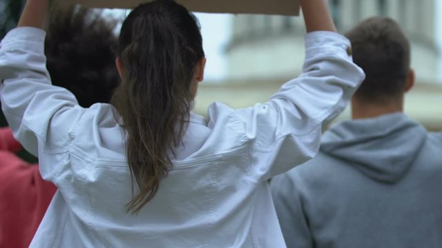 Employee crowd waving banners on strike, requiring better working conditions