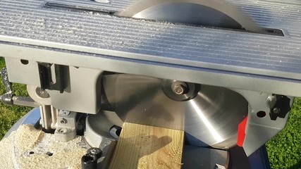 Detail of circular saw that cuts a wooden board,