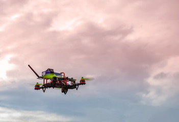 Fototapeta na wymiar DIY drone flying against cloudy sunset sky