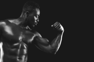 Fototapeta na wymiar Monochrome photo of african fitness model demonstrating his strong arm