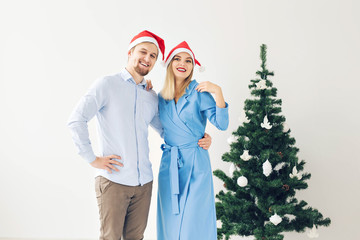 Winter holidays and family concept - Happy young couple near Christmas tree at home