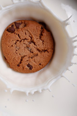 choco chip cookie falling and milk creating a milk splash