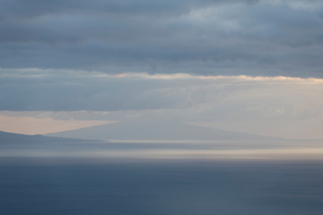 Obraz na płótnie Canvas Landscape image showing cloud layers over Faial island as seen from Sao Jorge Island, Azores