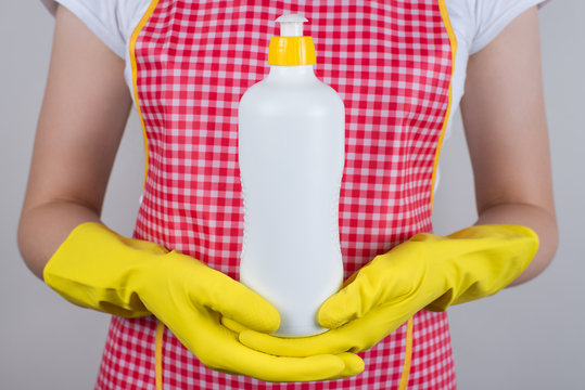 Cropped close up photo of satisfied wife using holding in hands bottle of liquid soap for cleaning kitcheware dishware isolated grey background