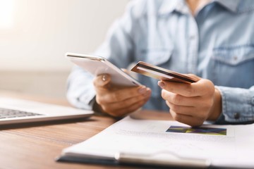 Businesswoman paying her bills online using application in smartphone