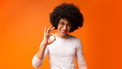 Happy black guy gesturing okay sign and smiling