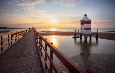 Italy beach - Lignano Sabbiadoro Lighthouse with beach at sunrise - obrazy, fototapety, plakaty