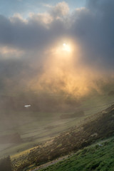Fototapeta premium low clouds over the Miradouro da Serra do Cume revealing the typical plots with walls landscape of Terceira