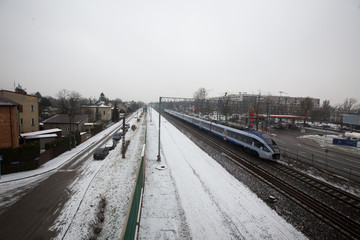 Train drive on a track in a cloudy and snowy day, Warsaw, Poland