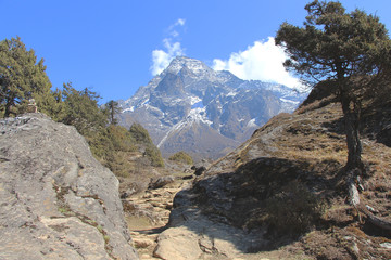 Pathway leading to the Khumbila mountain. View from the plain above the Namche Bazaar town near Kunde village in Himalayas in Nepal. Nature, mountains, outdoors, travel and tourism concept.
