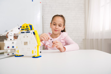 Girl programming robot, working with wires in class