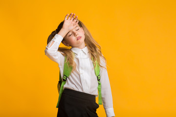 Little Schoolgirl Feeling Bad Touching Head, Yellow Background