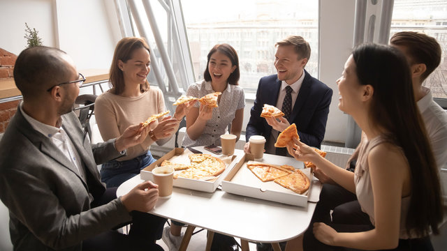 Overjoyed happy mixed race company employees celebrating special occasion.