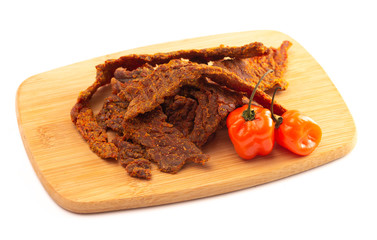 Habanero Pepper Flavored Gourmet Beef Jerky on a Wooden Cutting Board