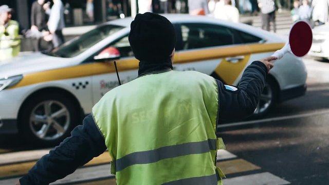 Traffic controller at work. The view from the back. The person regulates the movement of autotransport.