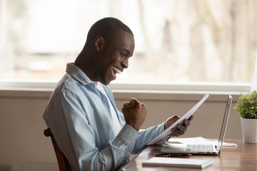 Excited biracial man feel euphoric reading positive letter