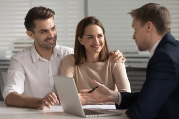 Smiling couple consulting with financial advisor or real estate agent.