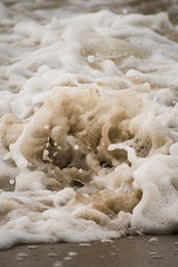 Obraz na płótnie Canvas Close-up of Foamy Water Splashing onto Shore