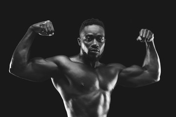 Fototapeta na wymiar Professional black bodybuilder demonstrating his amazing musculs
