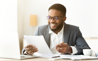 Handsome african american entrepreneur working with documents in office