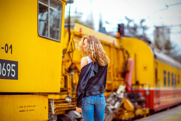 girl with freckles without makeup, near the yellow train at the station