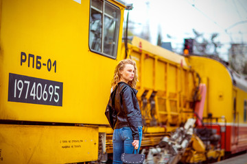 girl with freckles without makeup, near the yellow train at the station