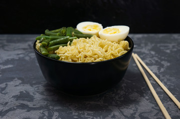 Asian noodles with green bean, boiled egg and chopsticks.